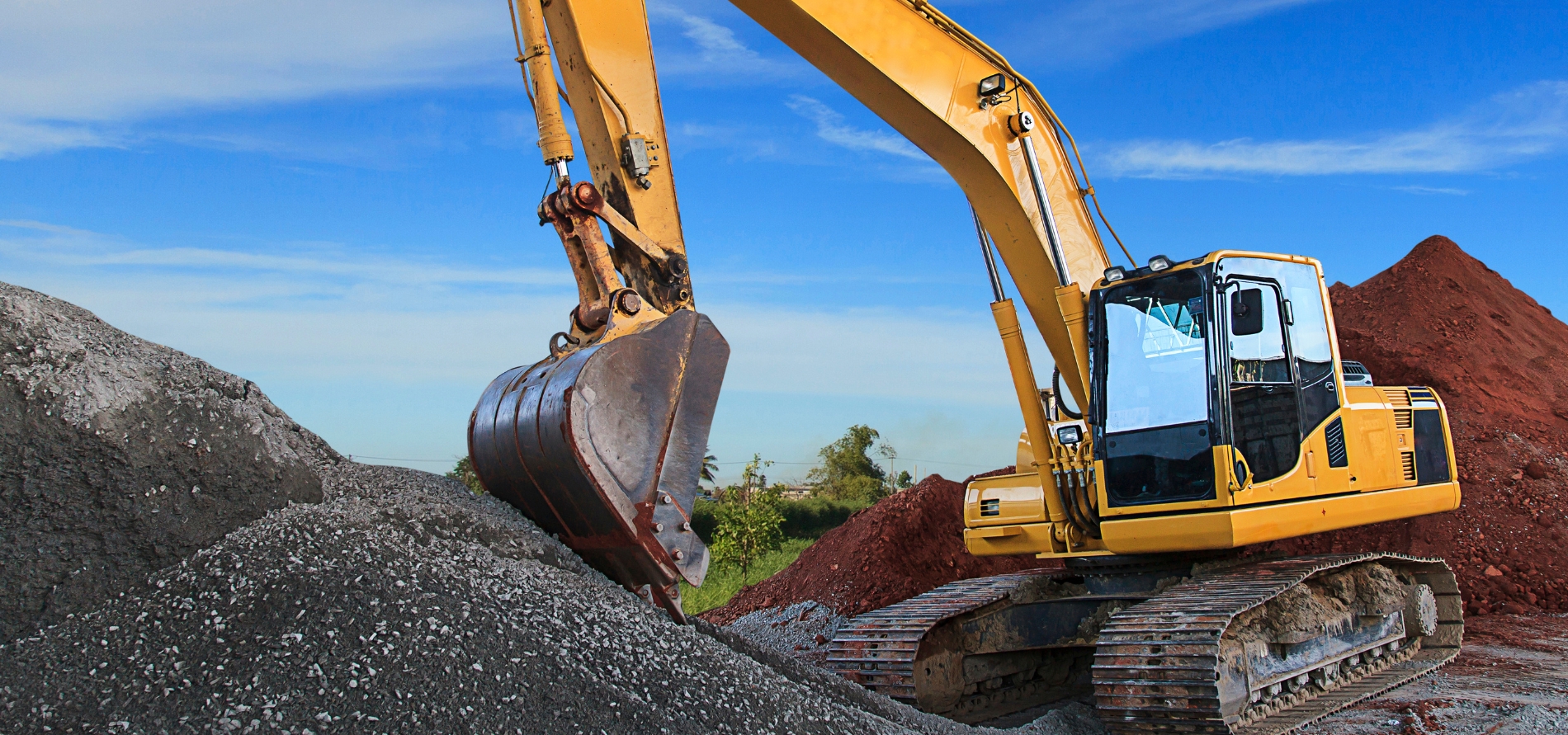 dump truck blue skies rocks red dirt mulch